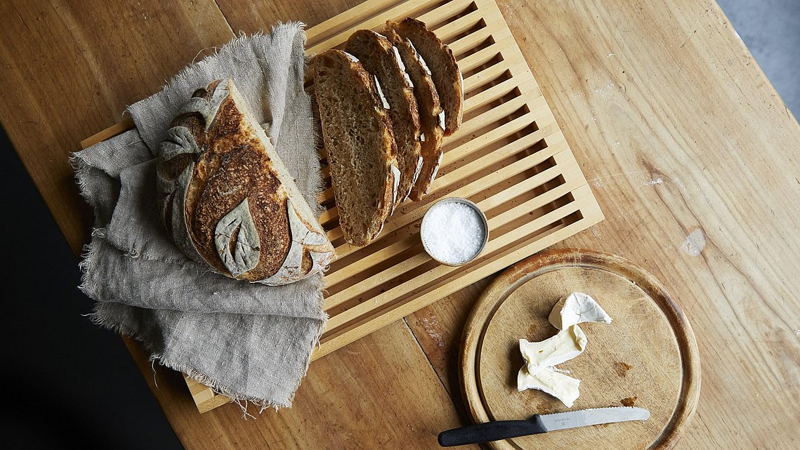 Frisches aufgeschnittenes Brot auf einem bulthaup Brotschneidbrett.